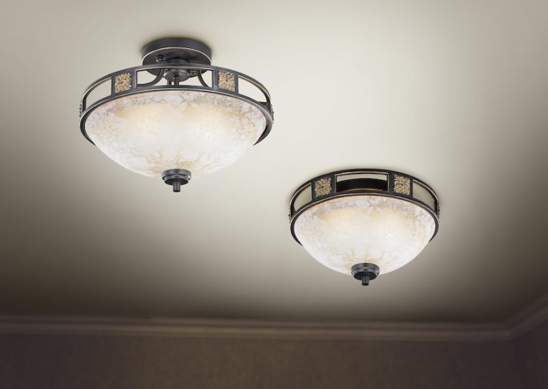 Chandelier on ceiling with classic design decorations and lights on in six lamps.