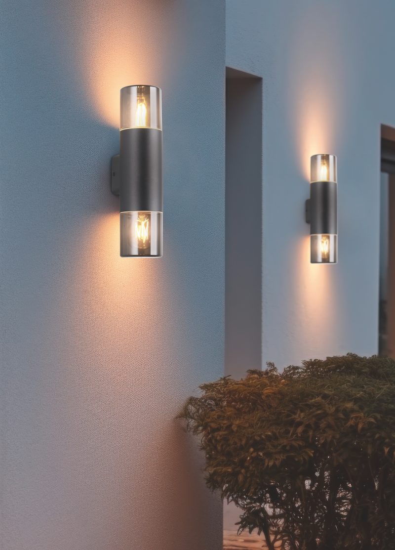 Wall lamp placed on the exterior of a building during night time with copy space. Modern electrical equipment for illumination.
