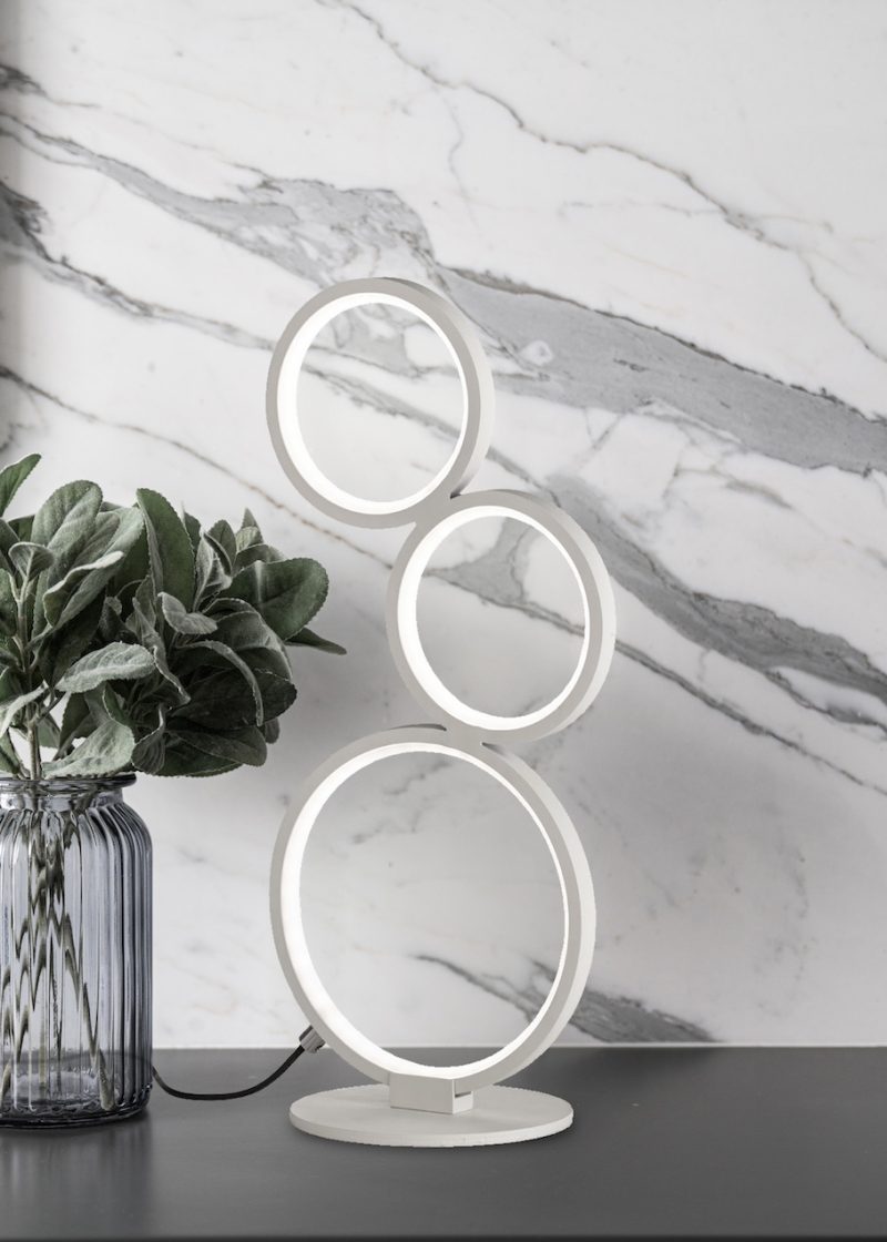 Artificial plant in glass vase compose with gold stainless mirror frame on gray spray-painted  working table with  marble wall in the background with copy space /apartment interior