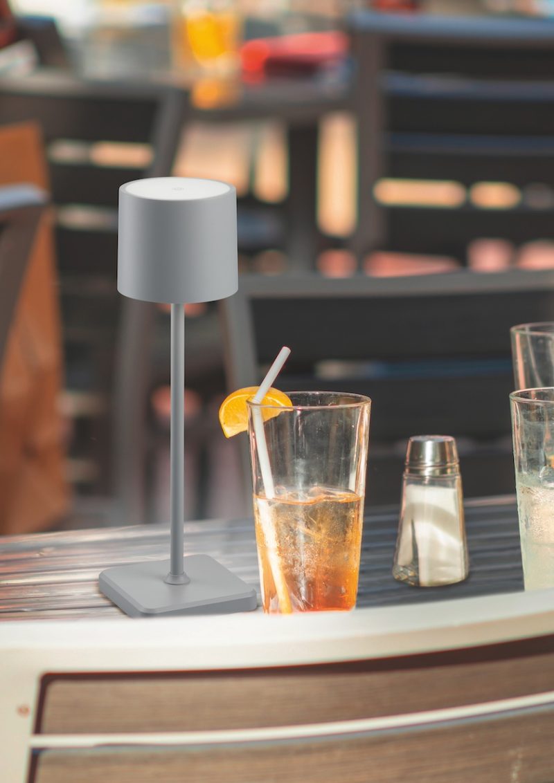 Restaurant glass cups on table with iced tea after a good meal with metal chairs and top with napkins in late shade