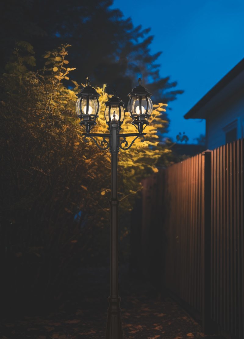 wall-mounted motion sensor light near a backyard gate
